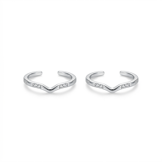 Pair of silver open cuff bracelets with small stones on a white background